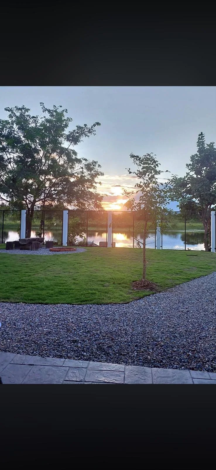 Garden with a view of the water at sunset.