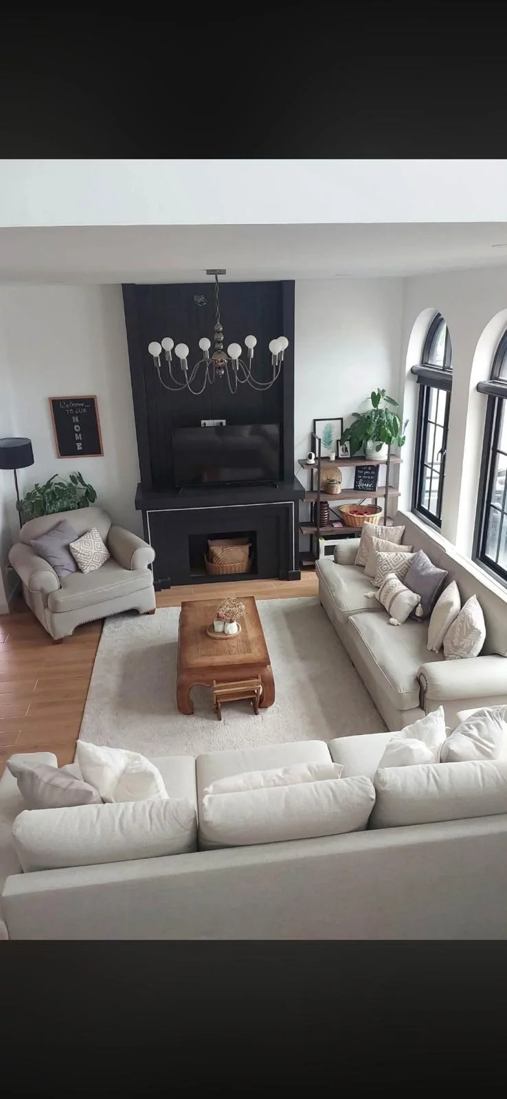 Living room viewed from above, with sofas, an armchair, a wooden coffee table and a fireplace.