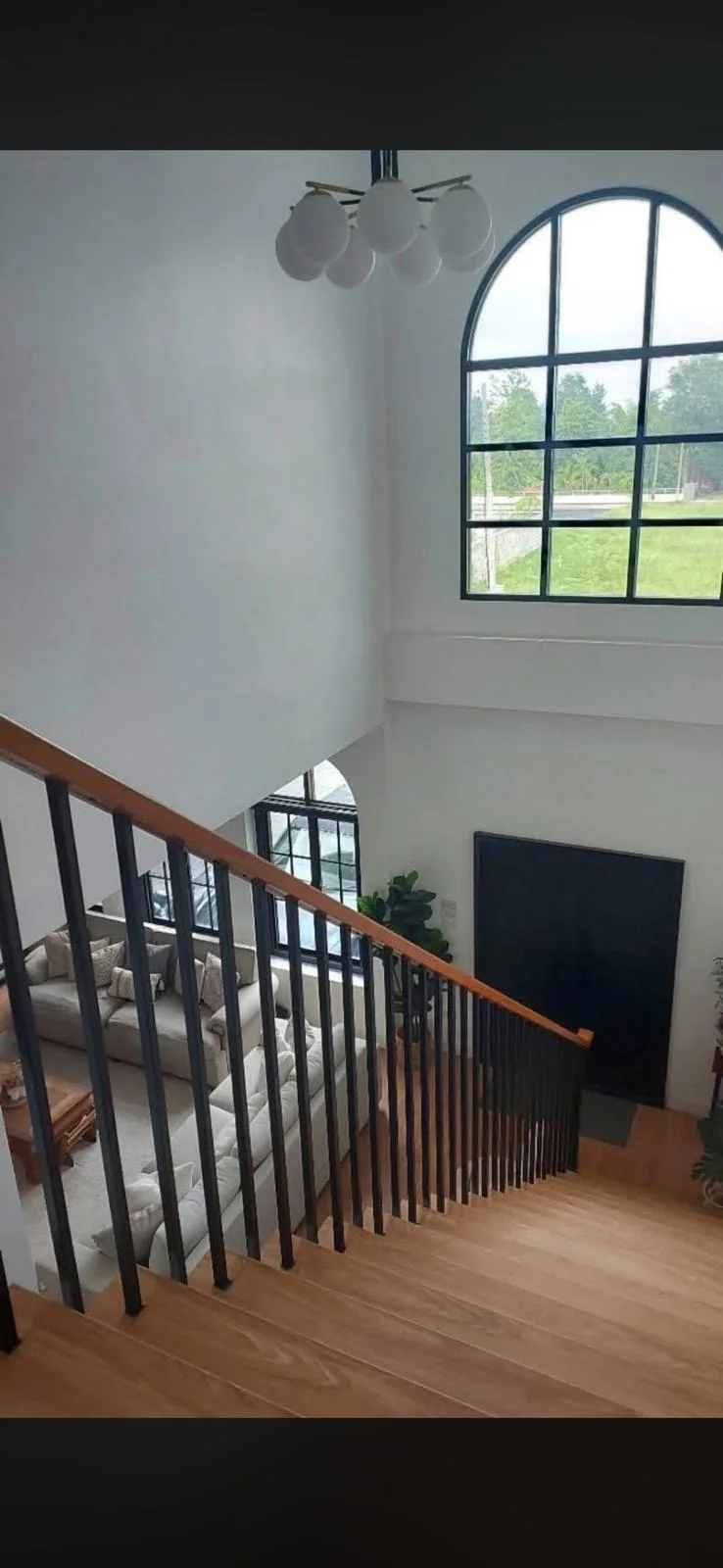 Stair landing overlooking the furnished living space.