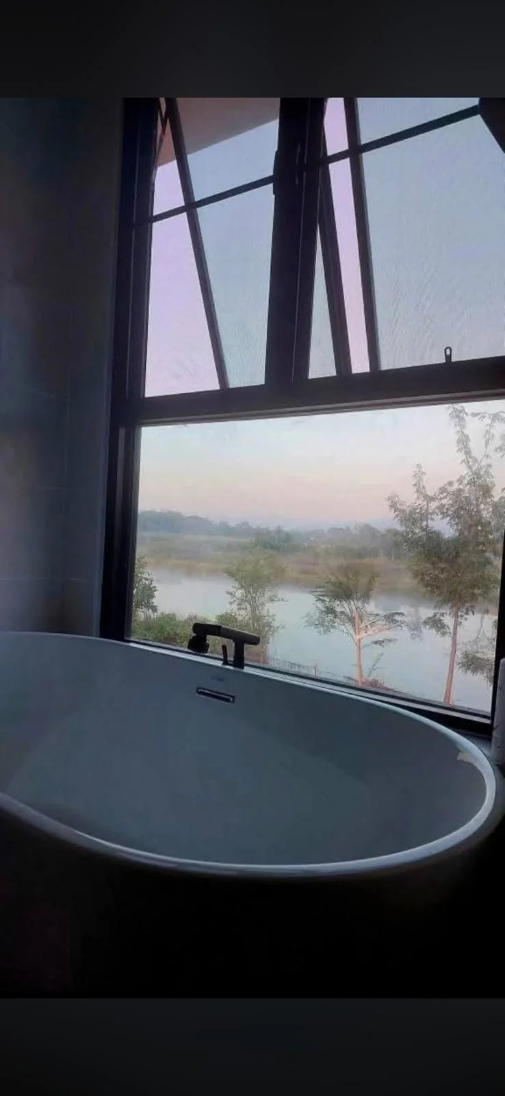 Bathroom with a bathtub and a view of the water.